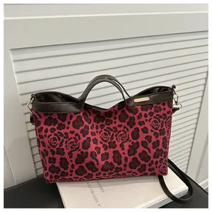 Détail du sac cabas avec imprimé léopard et roses, anses en cuir et boucle métal