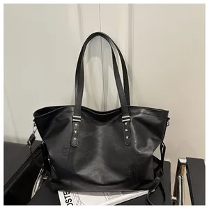 Detail of black tote bag with silver star rivets and removable shoulder strap