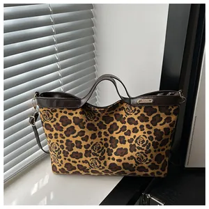 Détail du sac cabas vintage aux motifs léopard et rose avec plaque en métal doré