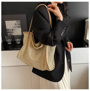 Detail of hand-woven straw tote bag with brown leather handles and textured knit pattern