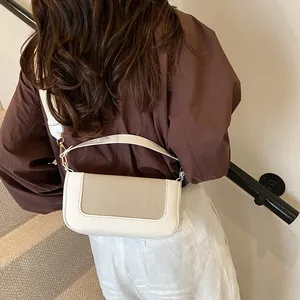 Detail of white rectangular crossbody bag with beige mesh texture and gold metal buckles