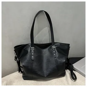 Detailed close-up of black PU leather tote bag with silver star rivets and soft texture