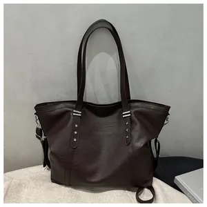 Detail of dark brown tote bag featuring silver star rivets and textured PU leather