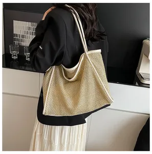 Detailed view of a woven straw tote bag with white trim worn by a model in a minimal setting