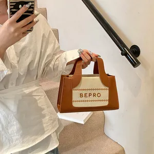Detail van de stijlvolle tweekleurige draagtas met leren bies en BEPRO-belettering