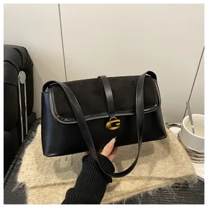 Detail of black patchwork shoulder bag with gold metal G buckle and textured leather