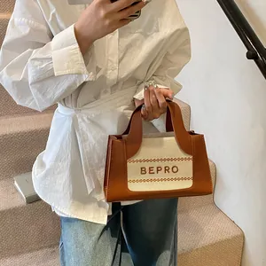 Chique handtas in kleurblok-design van bruin imitatieleer en beige canvas met tekst