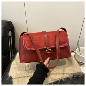 Detail view of the red leather shoulder bag with vintage gold G-shaped metal buckle closure
