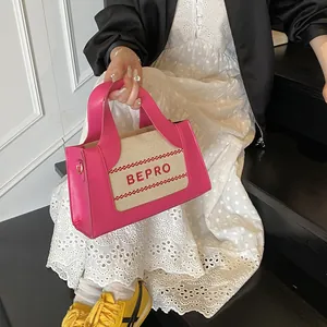 Detail van roze kunstlederen en beige canvas crossbodytas met BEPRO borduursel