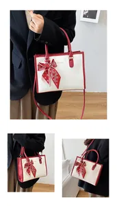 Vue détaillée du sac cabas gaufré crocodile blanc avec foulard en soie à motifs de cœurs rouges