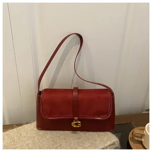 Detail view of red shoulder bag with golden G clasp and suede patchwork texture