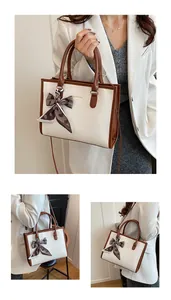 Détail du sac cabas en similicuir serpent blanc avec foulard en soie et logo doré
