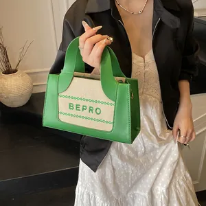 Stijlvolle groen-beige crossbodytas met BEPRO-borduurwerk gedragen door een model