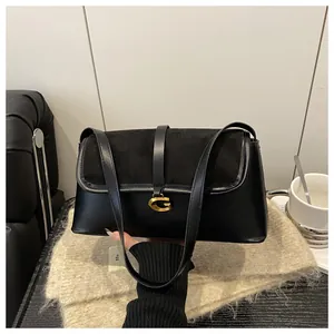 Detailed close-up of premium black leather shoulder bag with elegant gold metal buckle