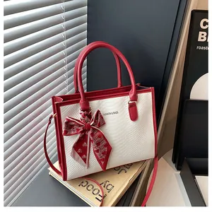Détail du sac cabas rouge et blanc avec texture serpent et foulard à cœurs