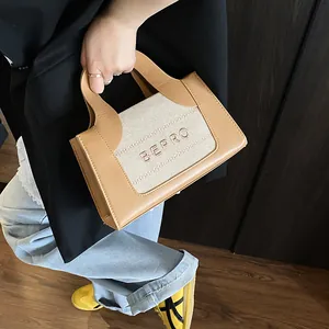 Gedetailleerde close-up van het geborduurde BEPRO-logo op een trendy handtas met kleurcontrast