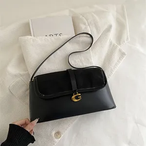 Classic black baguette shoulder bag with gold metal G-clasp on premium textured leather