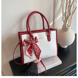 Détail du sac cabas rouge et blanc avec texture serpent et foulard en soie à cœurs