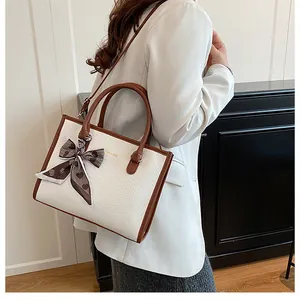 Détail du sac cabas blanc aspect serpent avec anses marron et foulard en soie à cœurs
