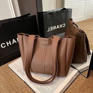 Detailed view of brown PU leather tote bag texture and reinforced vertical stitching