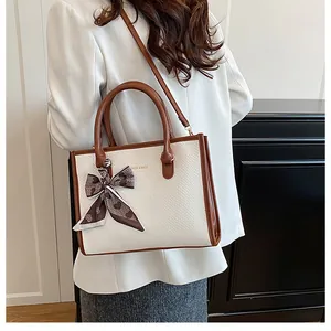 Détail du sac cabas blanc effet serpent avec anses marron et accessoire en foulard de soie