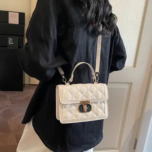 Chic beige quilted crossbody bag with metal lock shown on model with black outfit