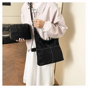 Grande borsa tote nera opaca con cuciture a contrasto e pochette coordinata indossata dal modello