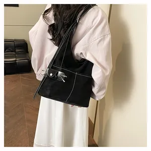 Dettaglio borsa shopper nera opaca con cuciture bianche a contrasto e fibbia decorativa