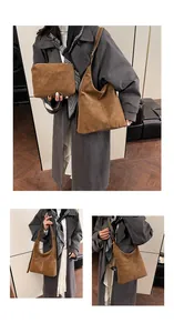Dettaglio borsa hobo in pelle scamosciata caramello con cuciture bianche e pochette