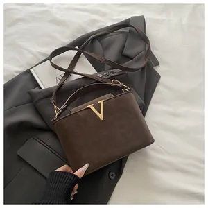 Detailed macro view of brown vintage textured bag with a gold metal V-shaped buckle