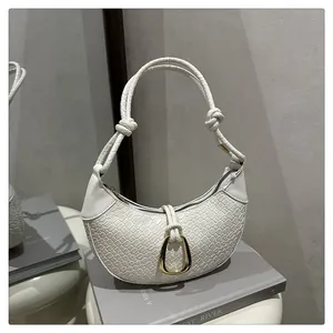 Détail du sac hobo en cuir tressé blanc avec boucle dorée et poignée nouée