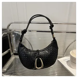Détail du sac hobo noir tressé avec boucle fer à cheval dorée et poignée nouée
