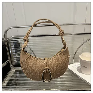 Détail du sac croissant kaki avec texture crocodile et poignée tressée à nœuds