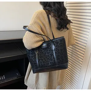 Detailed view of large leopard print tote bag worn on shoulder for daily commute