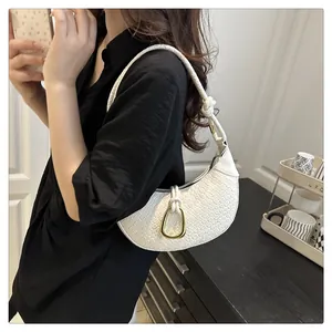Détail du sac demi-lune tressé blanc avec boucle en fer à cheval dorée et bandoulière