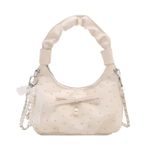 Chic beige pleated crescent bag with pearl accents and lace bow detail for women