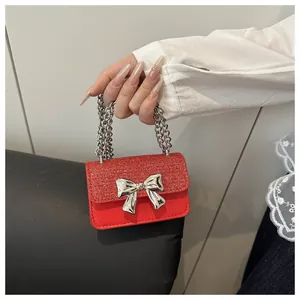 Detailed shot of a red sequined mini bag featuring a large silver bow and chain handle