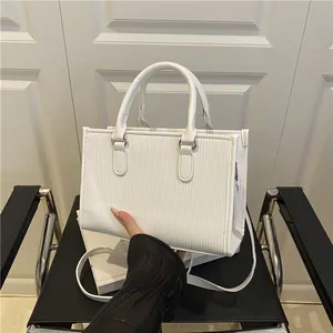 Macro shot of vertical striped texture on a white cylindrical leather tote handbag