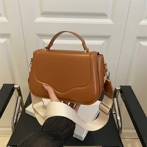 Caramel leather crossbody bag with top handle and stylish wide fabric shoulder strap
