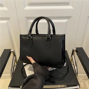 Detailed macro view of the vertical embossed texture on this black leather handbag