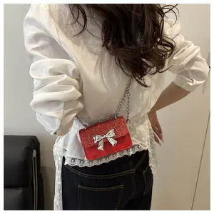 Detail of red mini square bag with sparkly rhinestones and a silver bow buckle