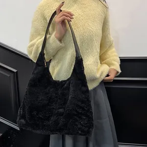 Sac hobo minimaliste en peluche noire avec bandoulière en cuir et fermeture dorée