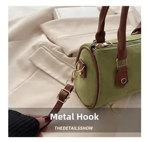 Détail des crochets en métal doré et de la bandoulière en cuir sur sac en daim vert