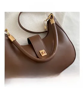 Detailed shot of dark brown crescent bag with gold twist lock and smooth leather texture
