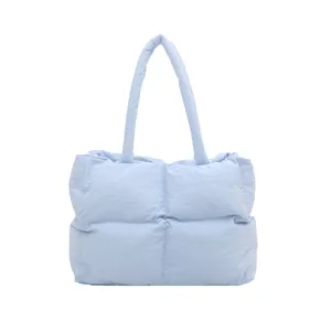 Quilted light blue puffer tote bag in a minimalist design with large square stitching