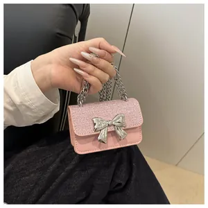 Detail of pink mini chain bag featuring sequins and silver bow metal ornament
