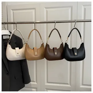 Detail view of four minimalist crescent bags in cream, camel, brown and black leather