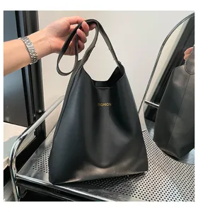 Vue détaillée d'un sac à main vintage en cuir noir mat avec inscription Fashion dorée
