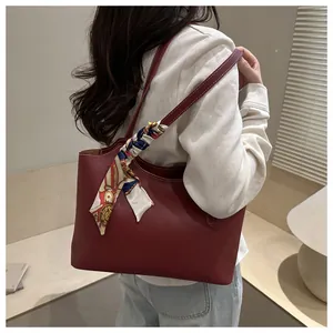 Detail of burgundy tote bag featuring white contrast stitching and a silk-feel scarf wrap