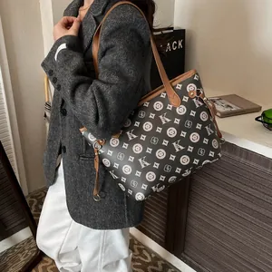 Retro monogram tote bag in black and beige with leather handles shown in lifestyle setting